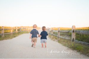 cute little boys walking towards the beach and making summer memories
