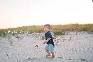 little boy playing in sand dune at jersey shore
